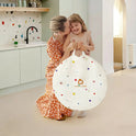 A woman kisses a young girl holding a colorful, round storage bag—just right for storing the Adventure Crawl Tunnel (68″).