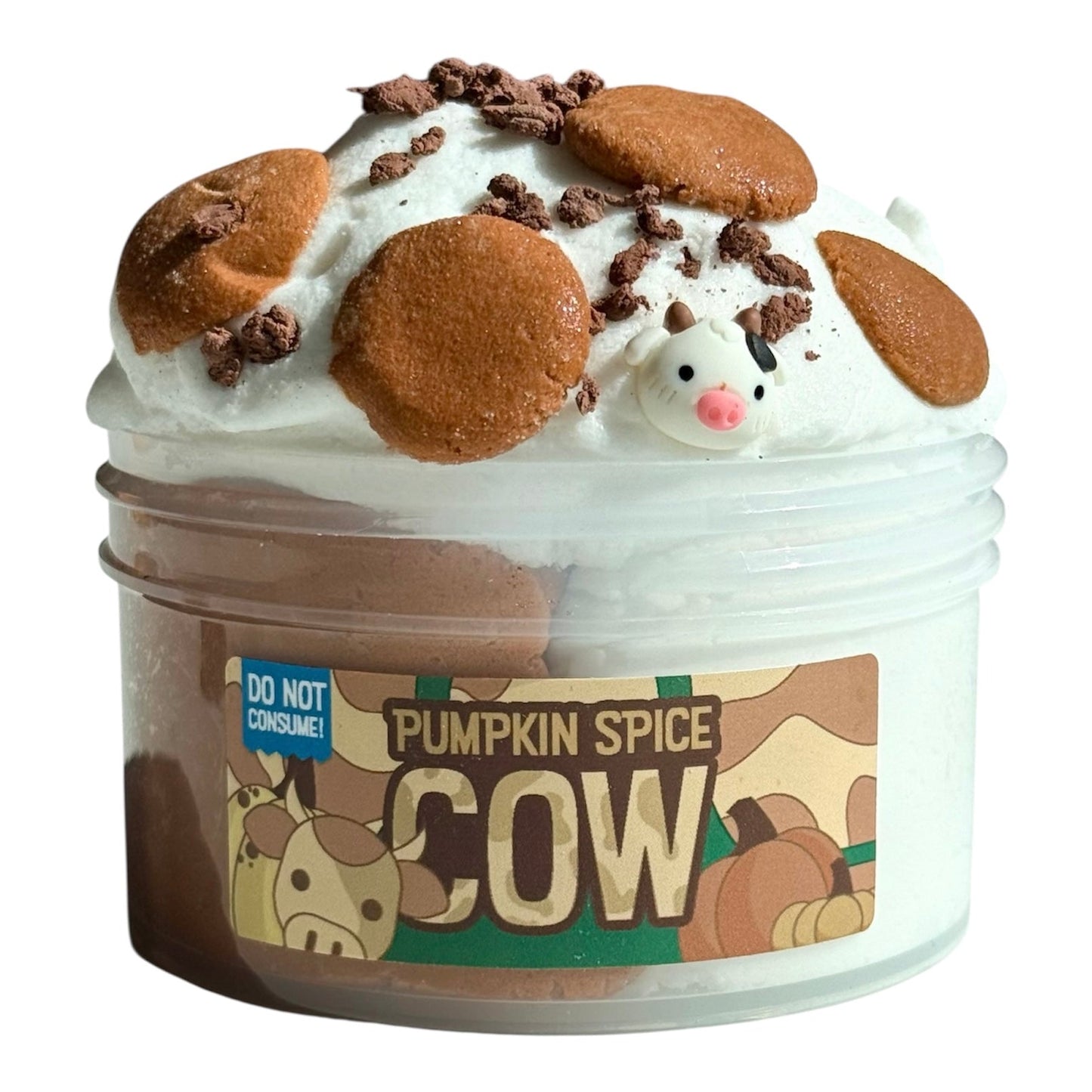 A 7 oz Pumpkin Spice Cow Cloud Cream Slime, scented like pumpkin cream, filled with fluffy white slime, topped with cookie shapes, chocolate chunks, brown bits, and a cute cow charm. Label includes a "Do Not Consume" warning.