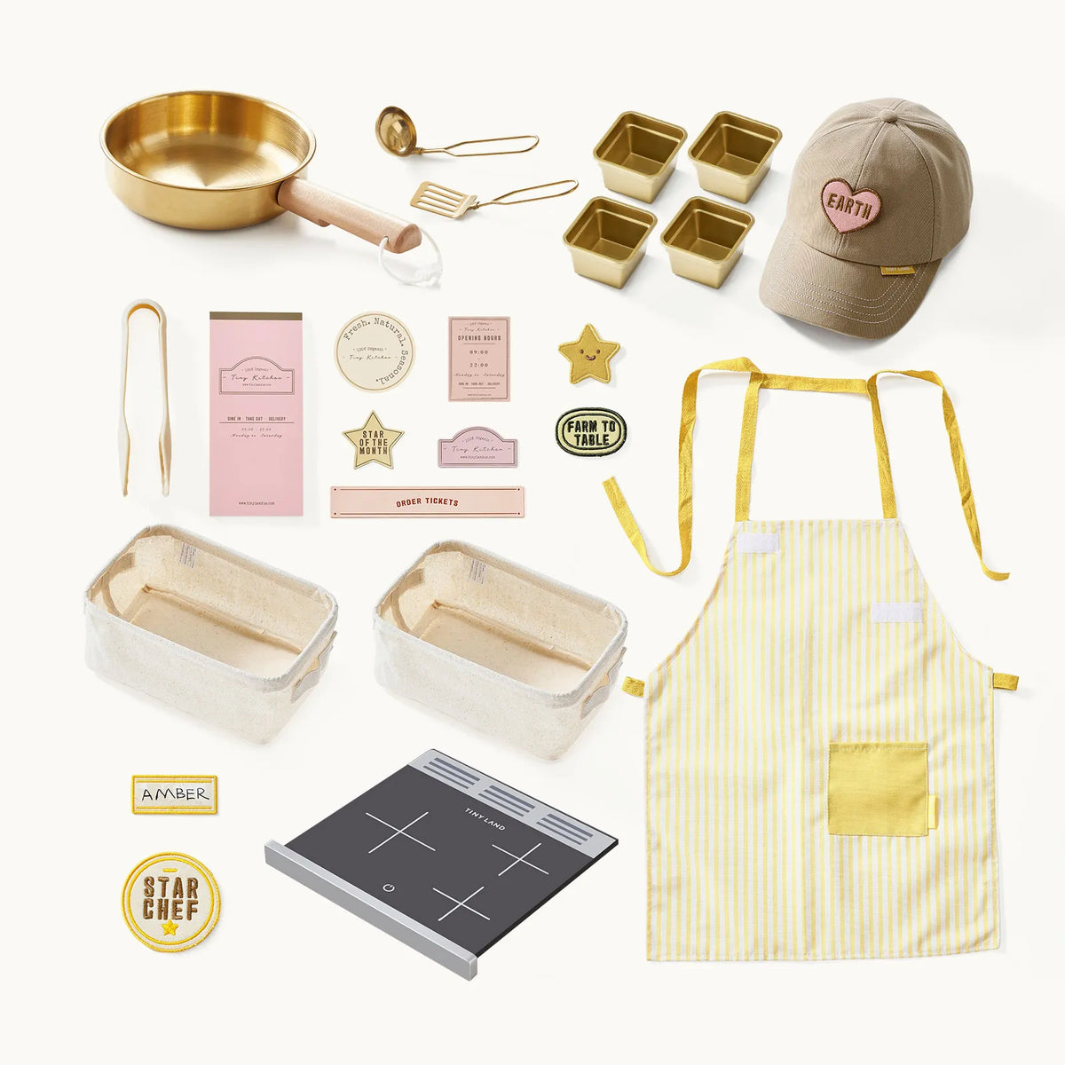 BistroSwitch 2-in-1 Play Kitchen & Bistro accessories including a gold pan and mini tins, a tan baseball cap, yellow-striped apron, two storage bins, a portable stovetop, and various signs and badges.