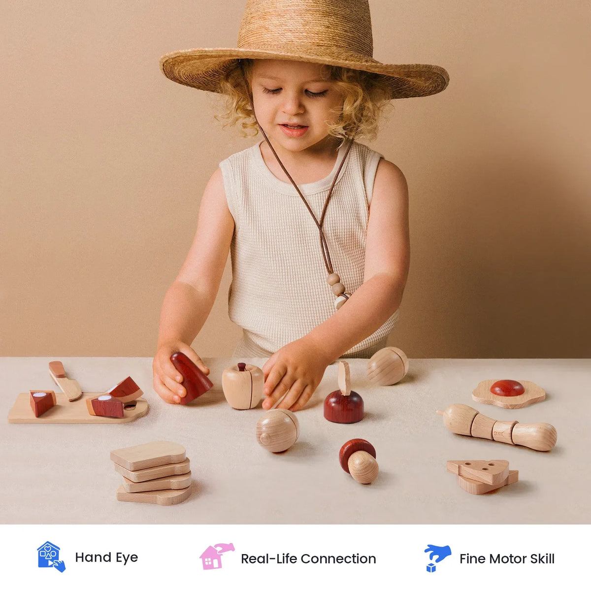 A child wearing a straw hat uses the knife from a Wooden Cut & Play Food Set with Knife and Board to play with wooden fruits and veggies on a cutting board.