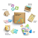 Flat lay of Tiny Land® Montessori Toys for Newborns (4–6 Months), featuring labeled sensory toys: silicone blocks, spinning rainbow, milestone cards, parent’s guide, pull-and-discover box, and “Tiny Garden” cloth book for fine motor skill development.