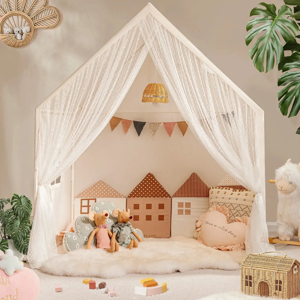 A Large Cozy Cabin Play Tent with Star Lights featuring sheer curtains, two mouse dolls, house-shaped pillows, and a heart-shaped pillow on a plush rug.