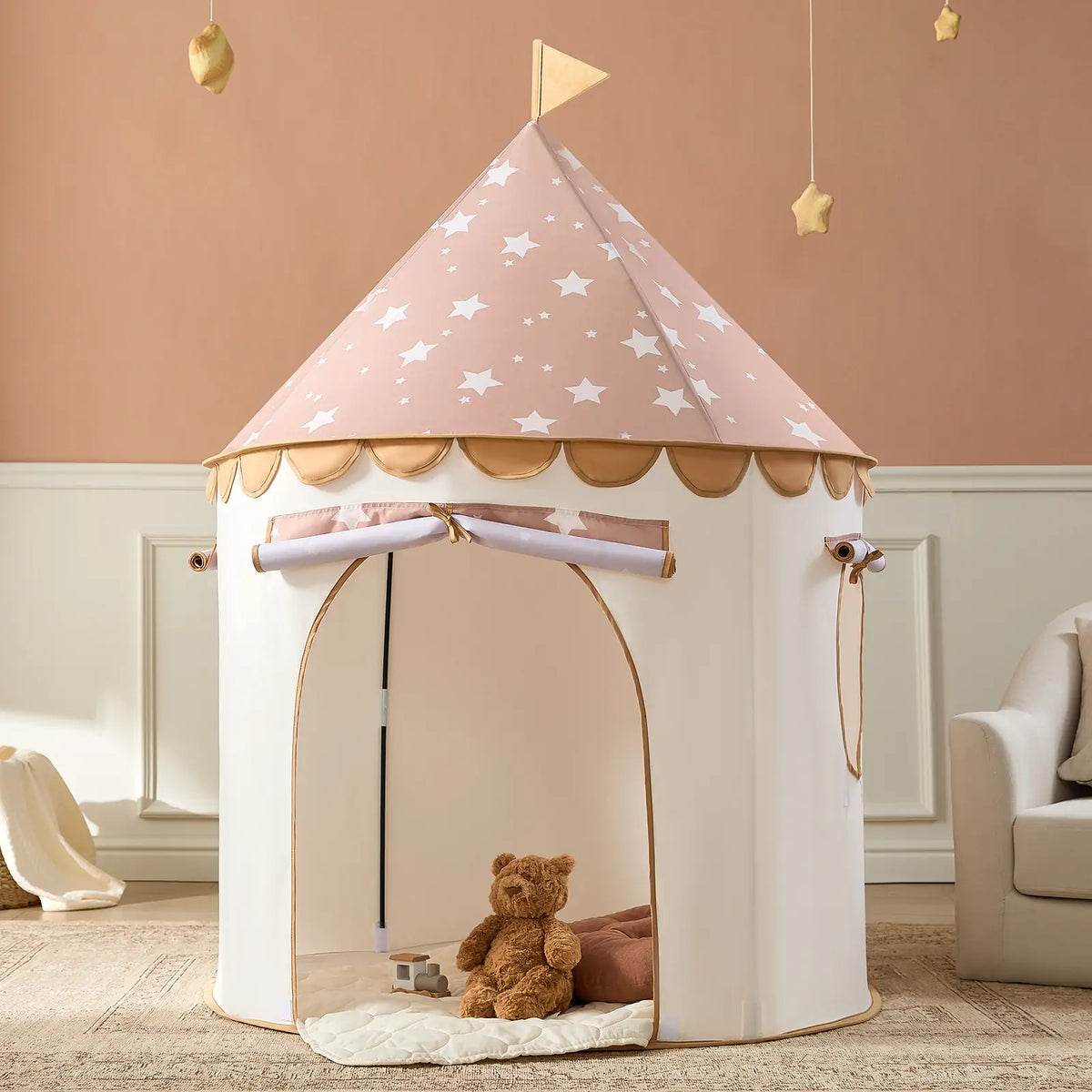 A brown Starry Indoor Play Tent for Toddlers shaped as a hexagon with a star-patterned roof, featuring an open doorway with a teddy bear sitting inside.