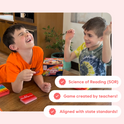 Two boys laugh while practicing with the Sight Words Game + Extra Rainbow Mats, using sight word cards and rainbow-colored fidget mats.