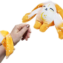 A person wears an orange, star-patterned Ori Mini Wrist Hugger – Magnetic Sensory Plush, featuring a plush wrist cuff and a matching magnetic rabbit-shaped comfort companion.