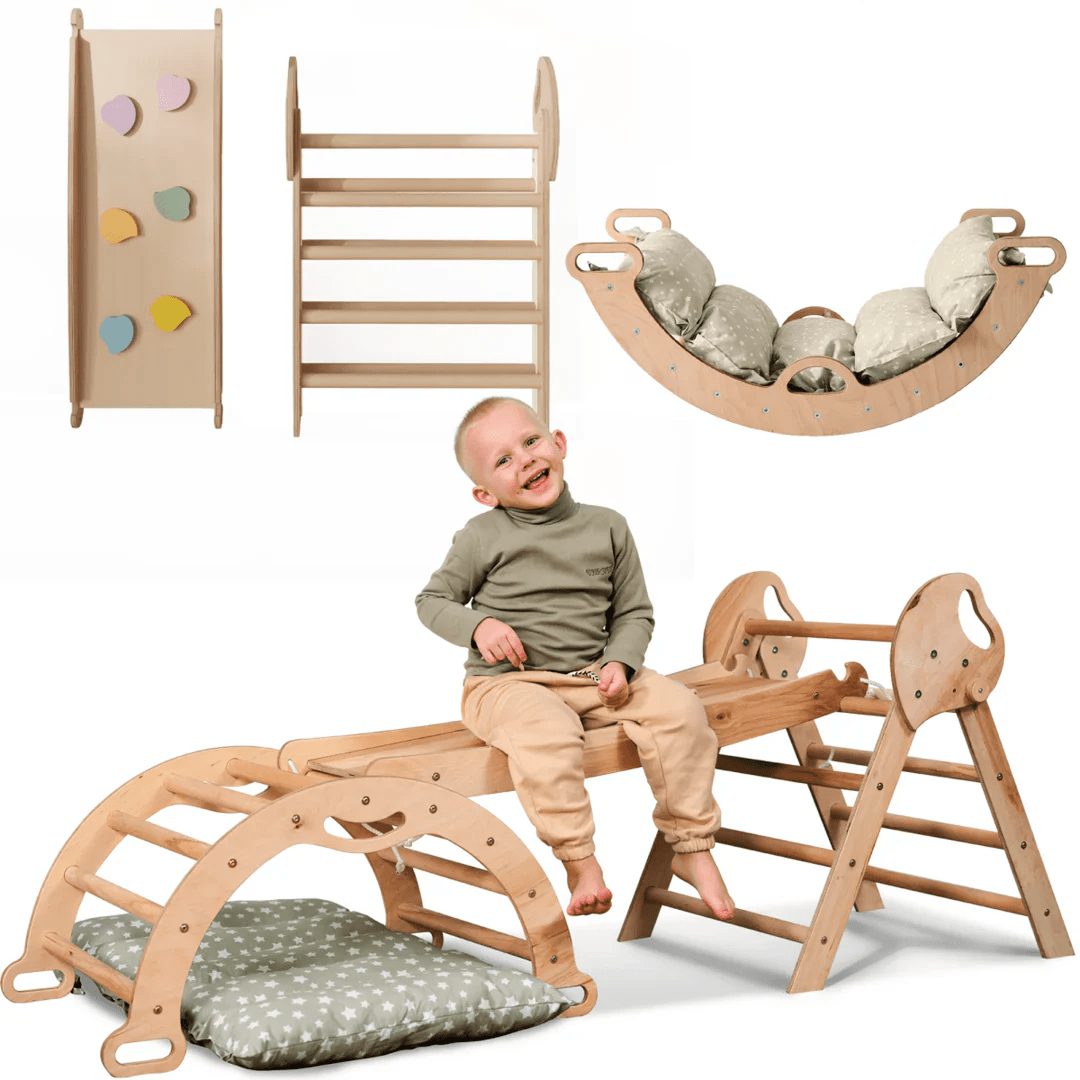 A smiling toddler sits on the beige 4in1 Montessori Climbing Set for ages 1–3, featuring a Pikler triangle, arch, slide board, and cushion—all crafted in light wood with neutral tones.