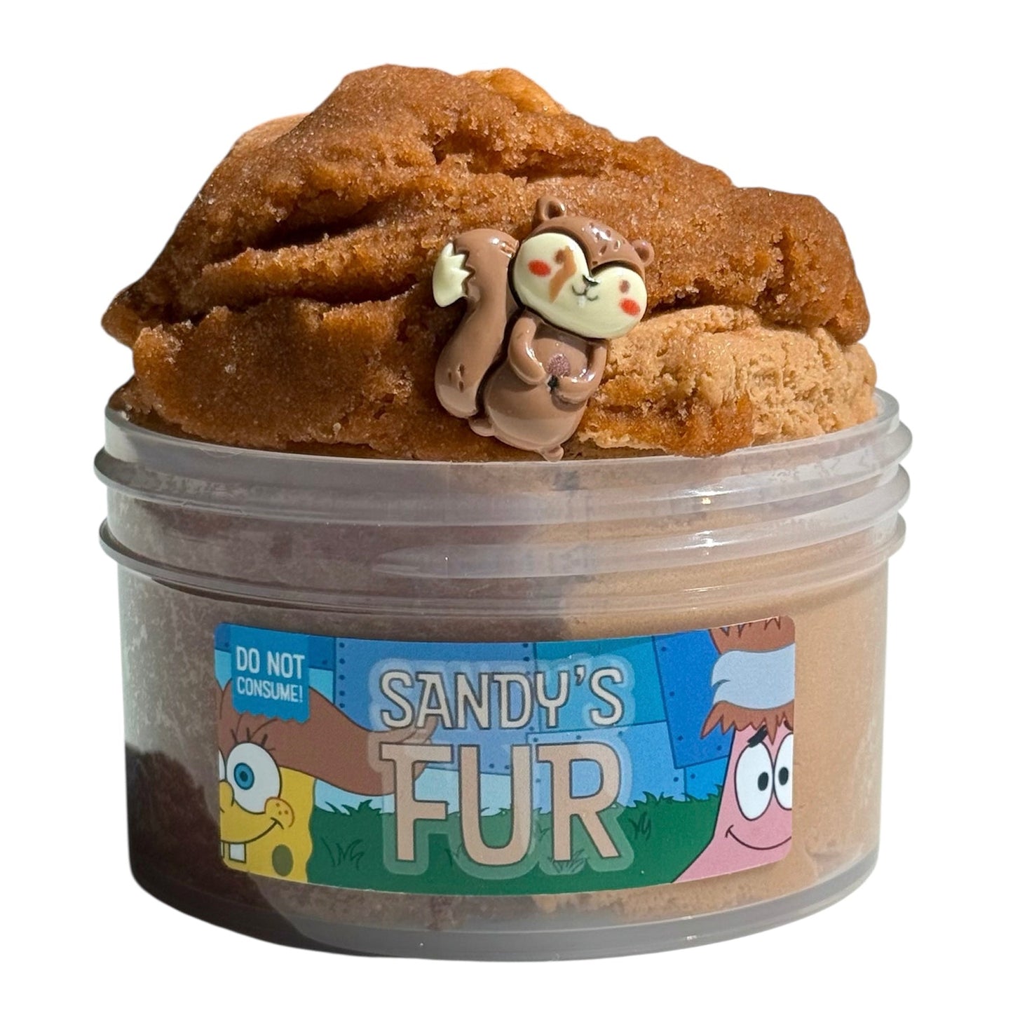 Sandy's Fur Brown Icee Cloud Cream Slime (7 oz) has an iced tea scent, comes with a squirrel charm, and features cartoon characters plus a "Do not consume!" warning on the label.