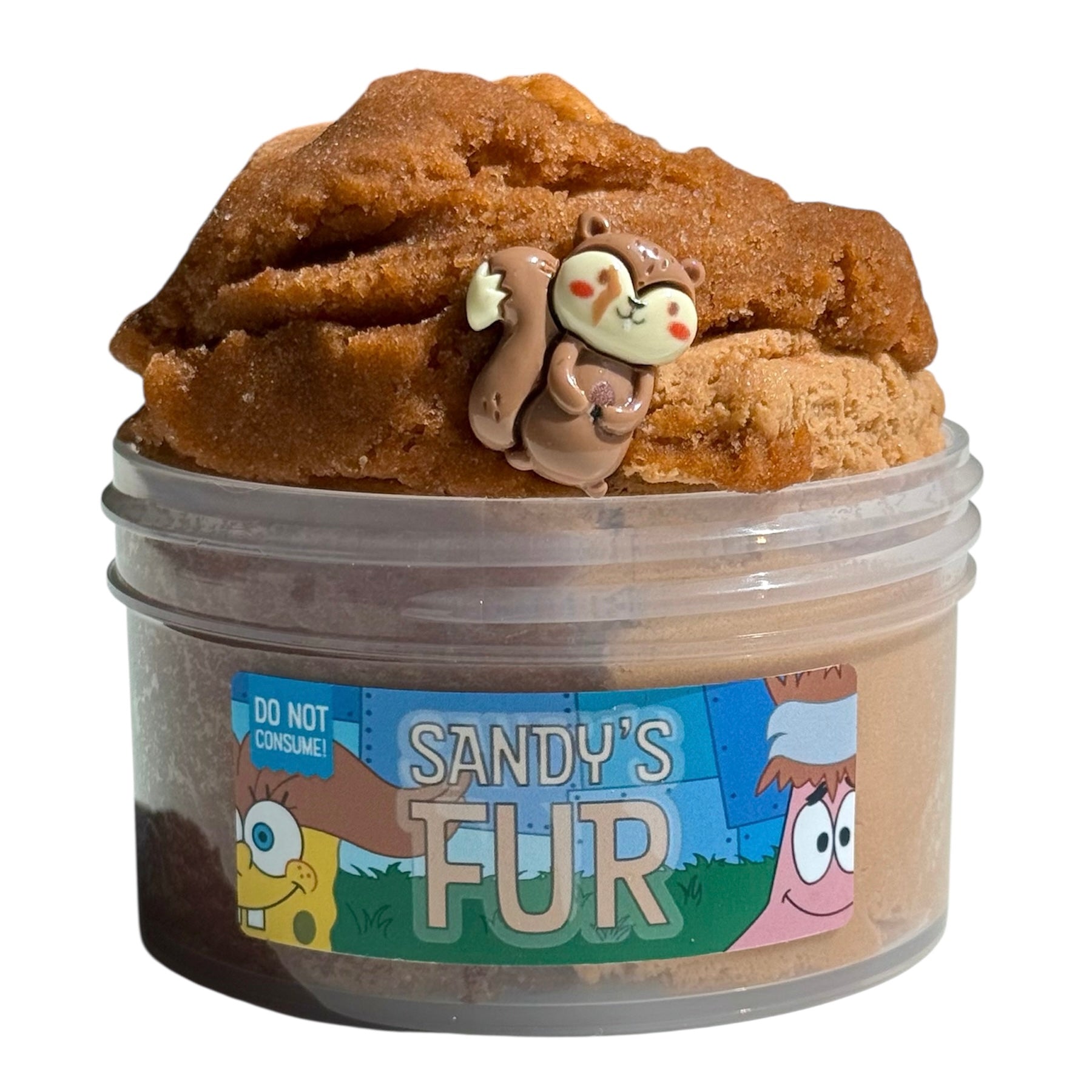 Sandy's Fur Brown Icee Cloud Cream Slime (7 oz) has an iced tea scent, comes with a squirrel charm, and features cartoon characters plus a "Do not consume!" warning on the label.