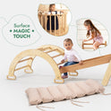 A baby sits on the 5in1 Montessori Climbing Set, resting on the wooden ramp with a soft cushion nearby. Two insets show children playing with different components of the set, including the Triangle Ladder and Arch/Rocker. Decorative stars surround text that reads Surface MAGIC TOUCH.