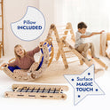 Two kids play indoors: a girl lounges on a curved rocker with a blue pillow, while a boy slides down the Apollo 5in1 Climbing Set—Pikler Triangle, Net, Arch, Slide Board & Cushion for Little Astronauts. Text reads “Pillow Included” and “Surface Magic Touch.”.