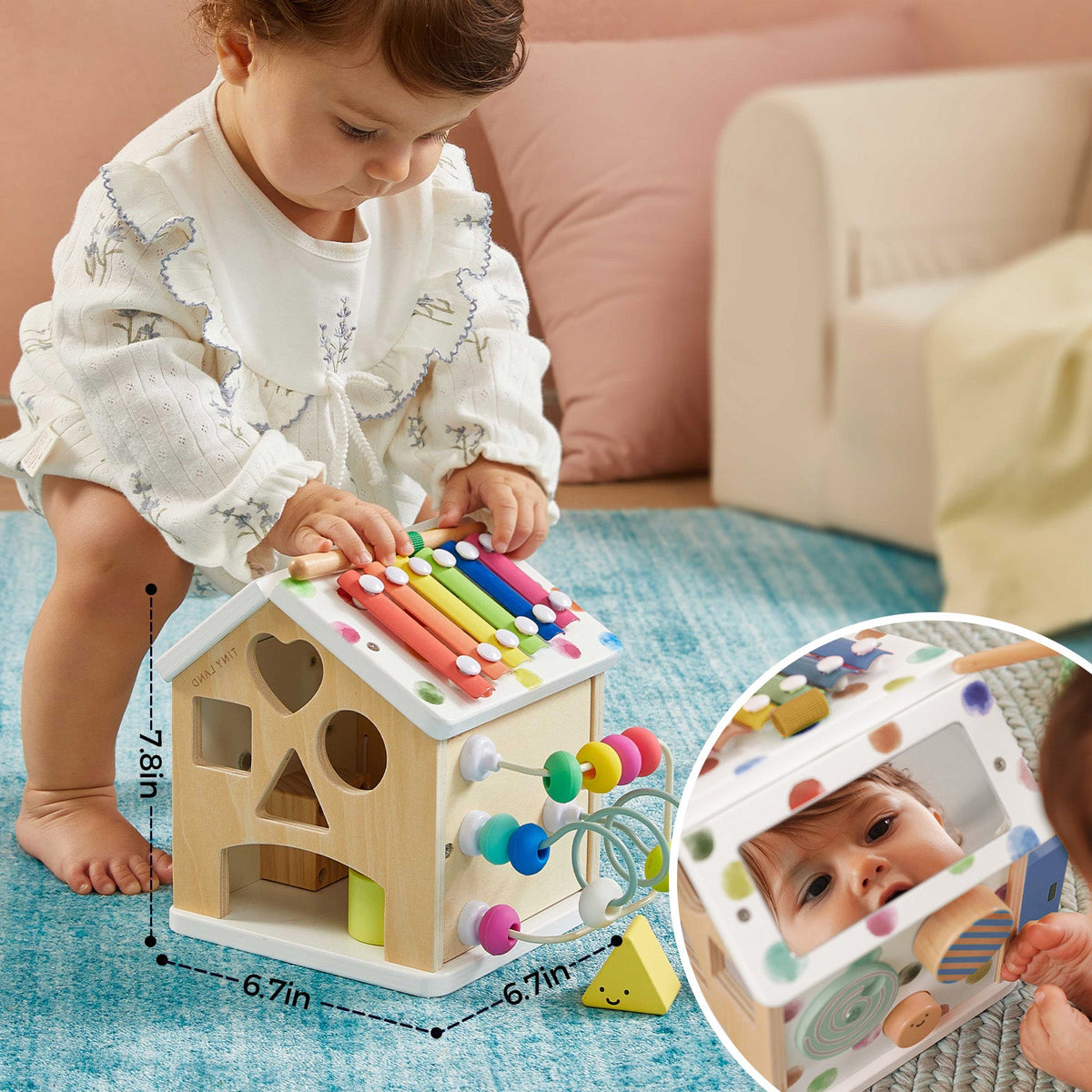 A toddler plays with a Montessori Cottage Activity Cube – Rainbow shaped like a house, featuring a xylophone, bead maze, and mirror to help develop fine motor skills.