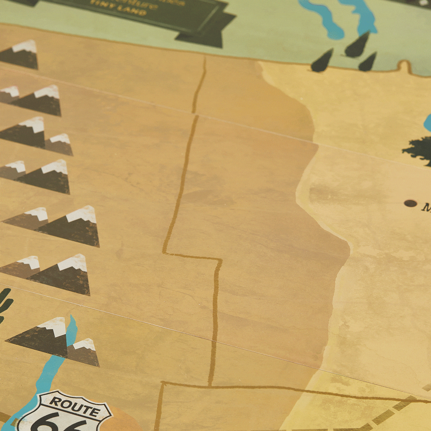 A section of a 1920s Railway Wooden Train Table with Sounds featuring an illustrated map with mountains, a river, and a Route 66 sign set in a vintage city scene.