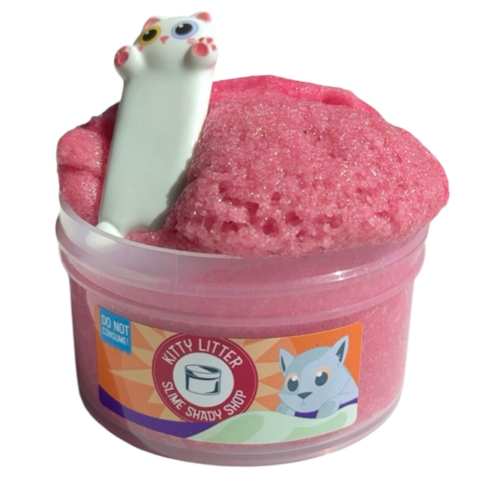The Pink Sand Slime Kitty Litter With Cat Charm And Pink Lemonade Scent (7 oz) features a cute white cat charm, cat illustration, and a Do Not Consume warning—perfect as a sensory play gift for slime lovers.