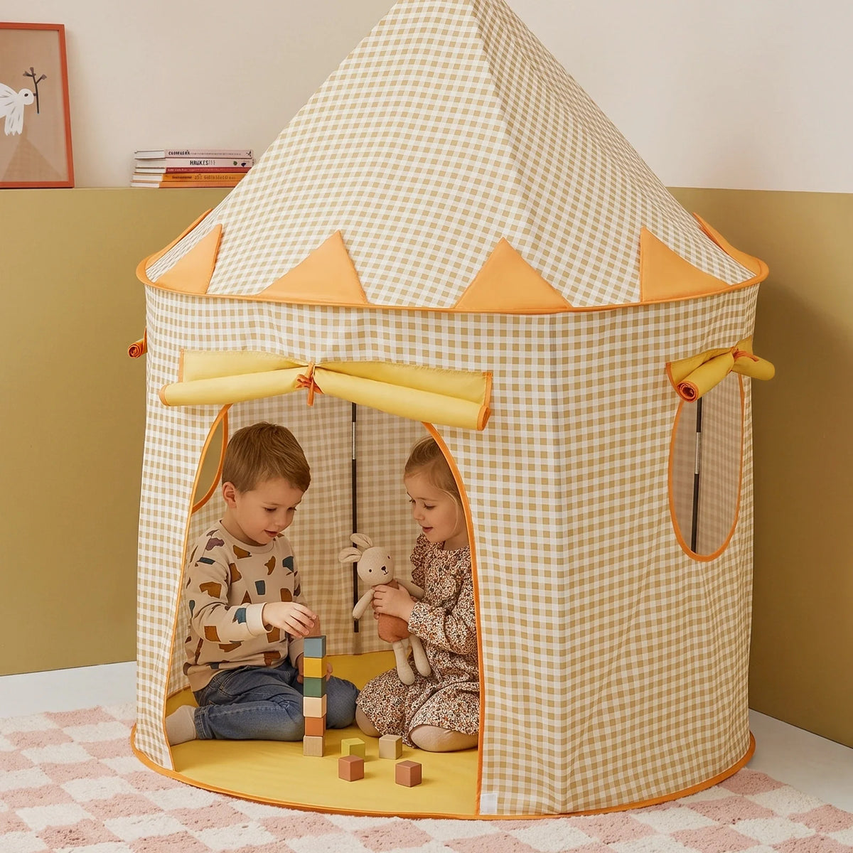 A boy and a girl sit inside a beige and white gingham Starry Indoor Play Tent for Toddlers, playing with wooden blocks and a toy rabbit.