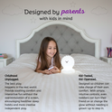 A young girl sits on a bed playing with a color-changing, lion-shaped Luther the Lion Silicone Night Light.