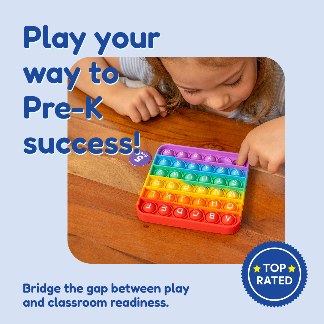 A child’s hands press a colorful, square alphabet-themed sensory pop-it toy from the Pre-K Readiness Backpack on a wooden table.