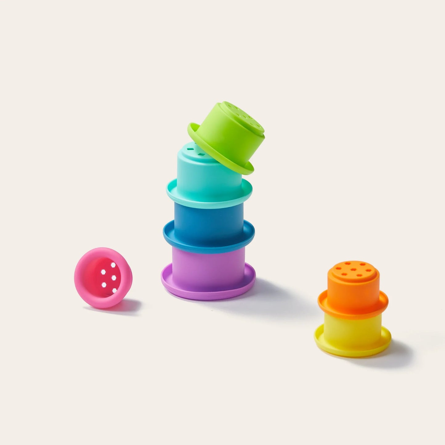 Tiny Land® Montessori Toys for Newborns (7–9 Months) features colorful, round stacking cups in bright hues—some stacked, others set apart—perfect for pairing with other Montessori toys or a sensory ball.