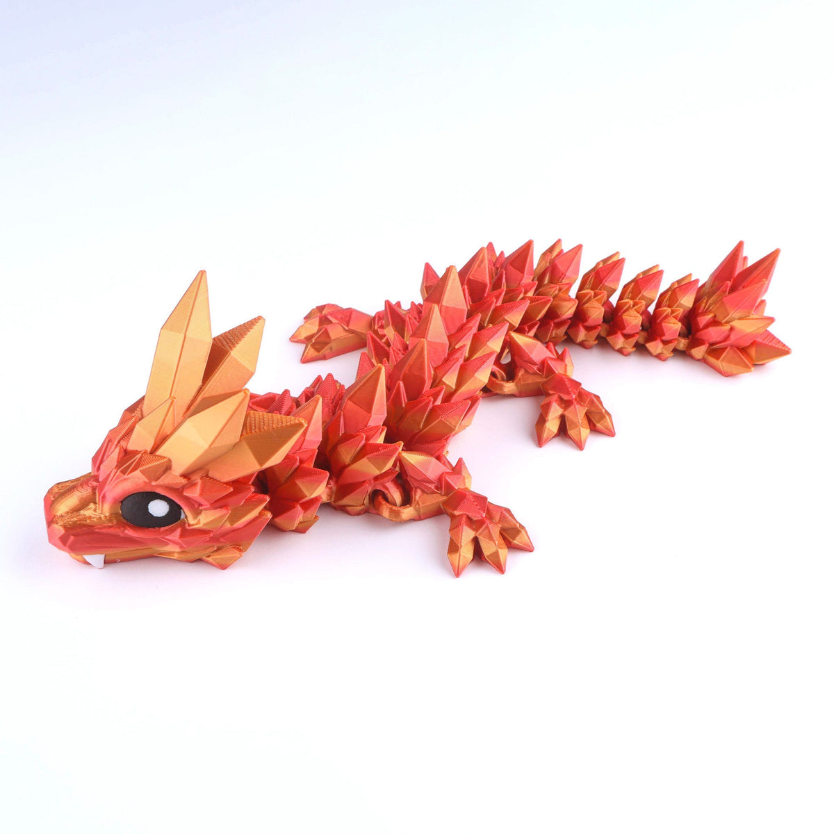 A shimmering red and gold Crystal Baby Dragon – Poseable Fidget Toy with an articulated, geometric, and crystalline 3D-printed appearance.
