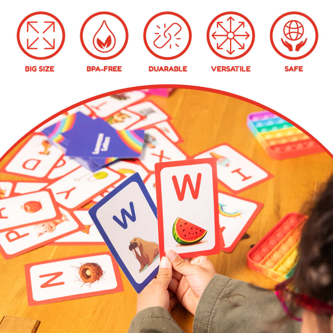 Hands hold two flashcards from the Card Pack Bundle (6 Learning Sets, 416 Cards) featuring the letter W with a walrus and a watermelon, surrounded by more ABC learning games and fidget toys on the table.