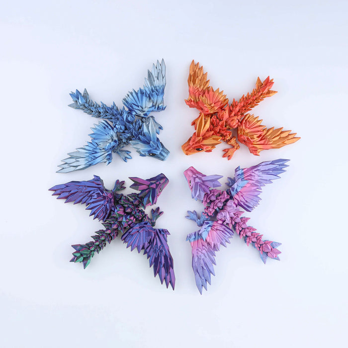 Four Crystal Wing Tadling Dragon – Mini Fidget (5″) toys in blue, orange, purple-green, and pink-purple, arranged in a circle on a white surface.