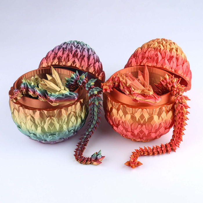 Two iridescent Crystal Dragon – Flexible Fidget Toy (10″–32″) figures with articulated joints rest inside their respective open, patterned eggs, one with a rainbow gradient and the other with an orange-to-red gradient.