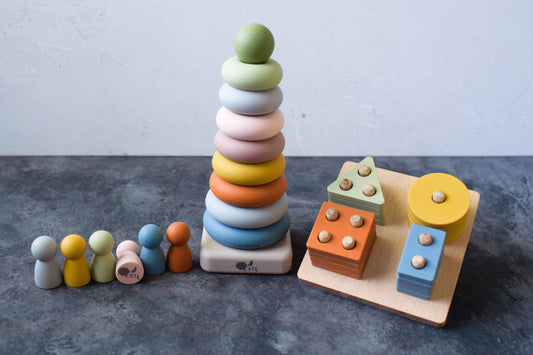 Montessori Sensory Starter Kit – 3 Toy Set including six silicone peg dolls, a multi-colored stacking ring toy, and a geometric shape sorting board.
