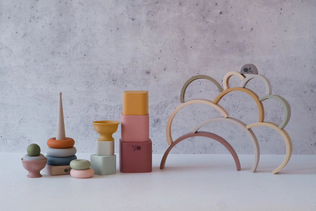 The Stack Happy Trio – Montessori Stacking Set includes a stacking ring tower, nesting blocks, a bowl, and an arched silicone stacker.