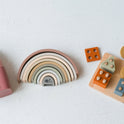 Silicone Stacking Cups (Set of 5), a rainbow stacker toy, and a wooden shape sorting board with various colored geometric blocks.