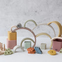 Montessori First Birthday Gift Set – 3 Toys featuring silicone arched rainbows, cubes, triangles, and a wooden peg board with stacking rings.