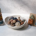 Montessori Fine Motor Play Bundle – 3 Toys including a silicone stacking ring tower, a bowl filled with assorted wooden and silicone mushroom-shaped pieces, and a Montessori shape-sorting board.