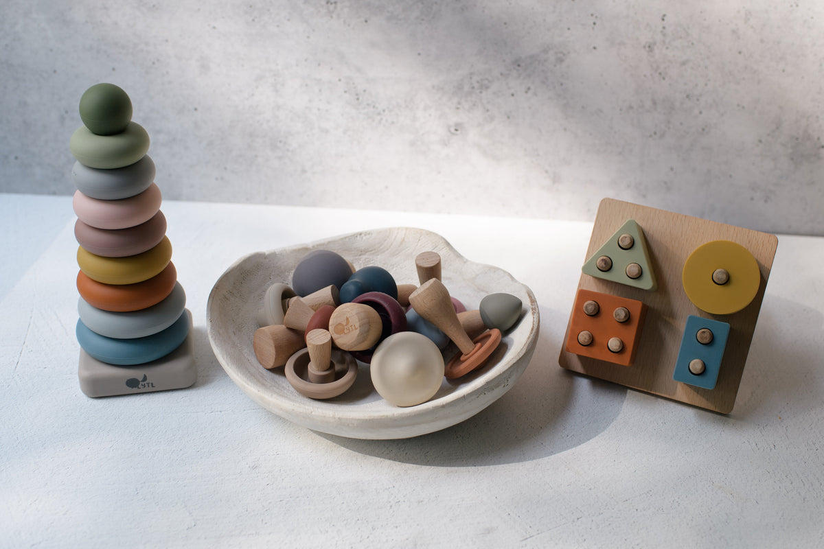 Mushroom Mix & Match Sorting Toy (24 pc) featuring a stacking ring tower, a bowl of wooden and silicone mushroom-shaped pieces, and a wooden shape-sorting board for color sorting and developing fine motor skills.