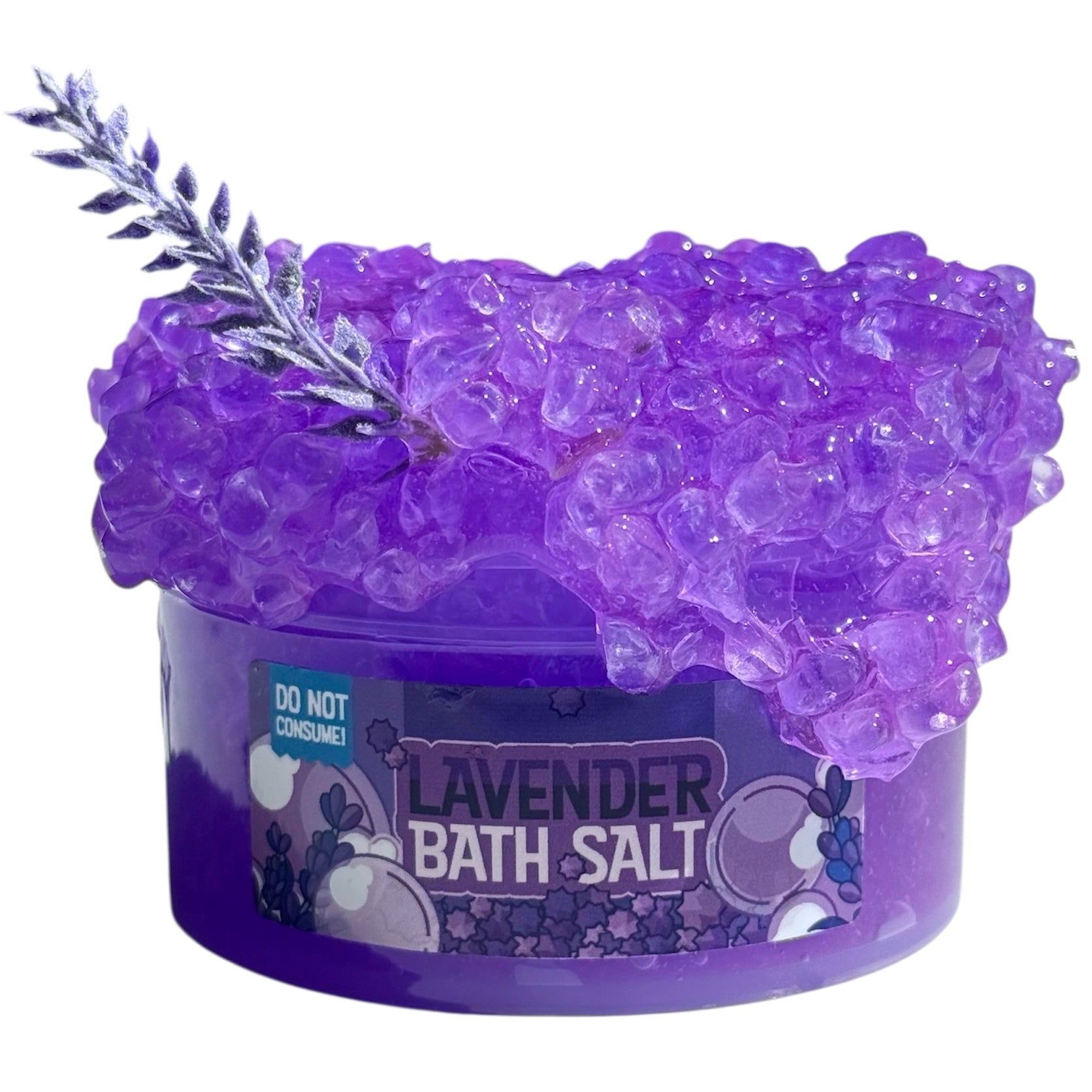 A clear container labeled "Lavender Bath Salt Purple Silica Slime" holds 7 oz of purple, crystal-like bath salts scented with lavender essential oil and topped with a lavender leaf charm. "Do Not Consume" is visible on the container.