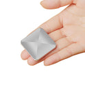 A hand holds a VKTECH Plastic Desk Toy Kinetic Skill Desktop Flip Rotating Fidget Spinner from Mainland China, featuring a metallic finish over durable plastic with a raised, pyramid-like surface and rounded corners.