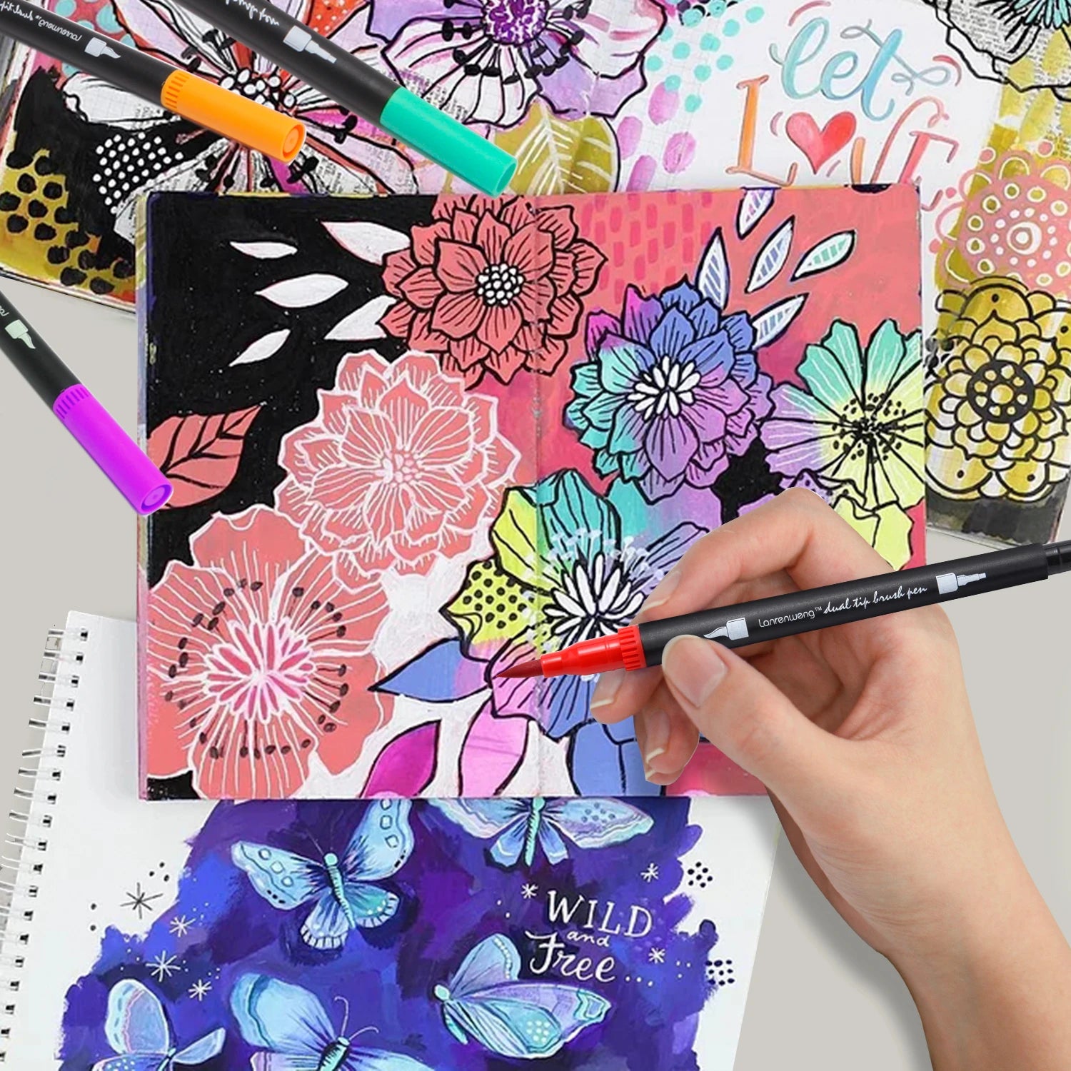 A hand showcases a Vibrant Dual Tip Brush Pen Marker over floral and butterfly art in pink, purple, blue, and yellow. The backdrop displays let love and wild and free, highlighting the pens artistic versatility.