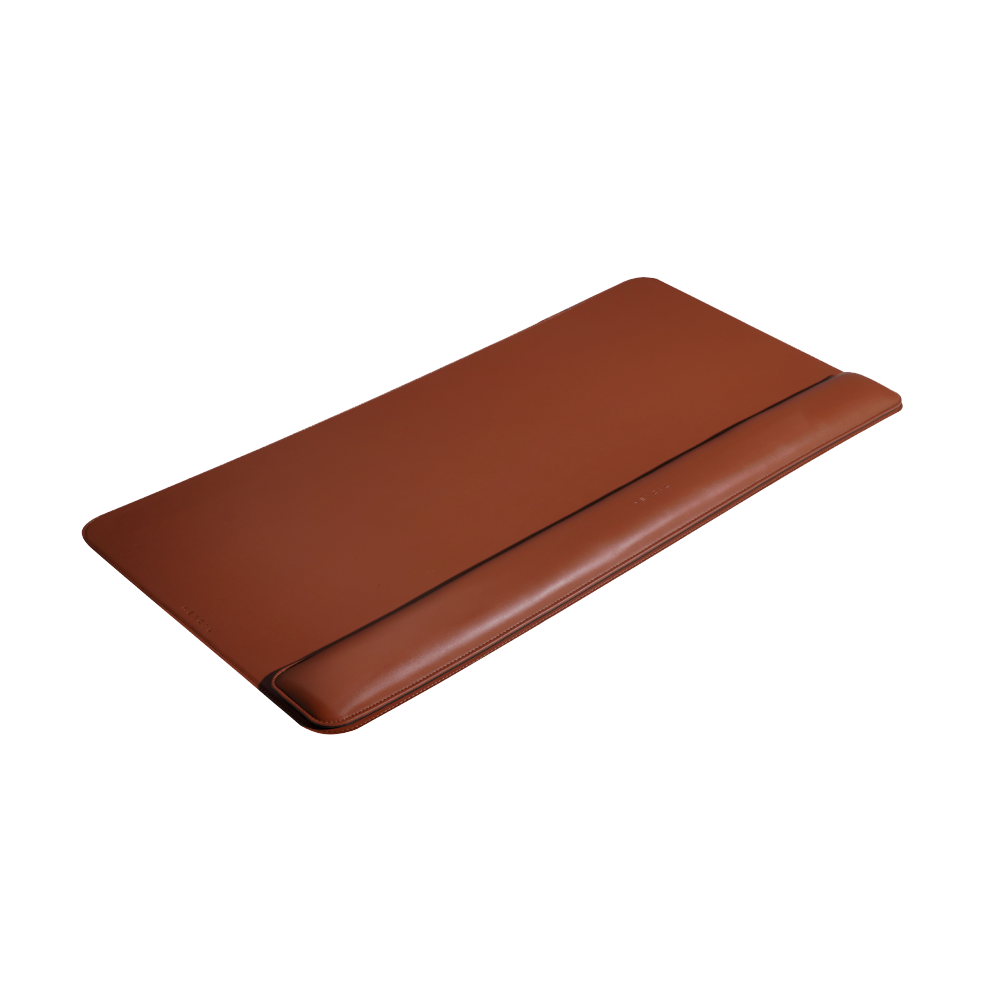 The brown Desk Mat Bundle, made from vegan leather and featuring an ergonomic wrist cushion, is displayed on a white background.