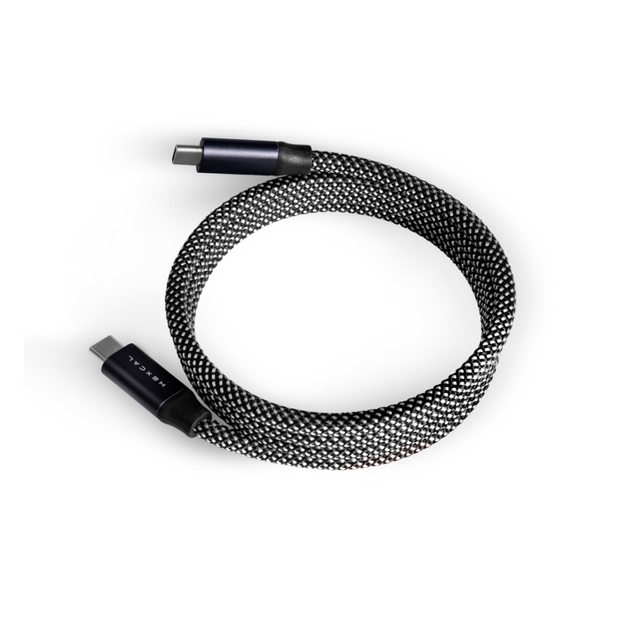 The Magnetic Charging Cable, a black and white braided USB-C to USB-C cable with Power Delivery and sleek black connectors, is coiled in a circle on a white background.