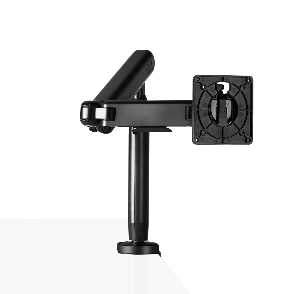 The Single Monitor Arm, in black, is mounted on the edge of a white desk for ergonomic setup. It has adjustable joints and a mounting plate for your monitor. The plain white background highlights the workspace.