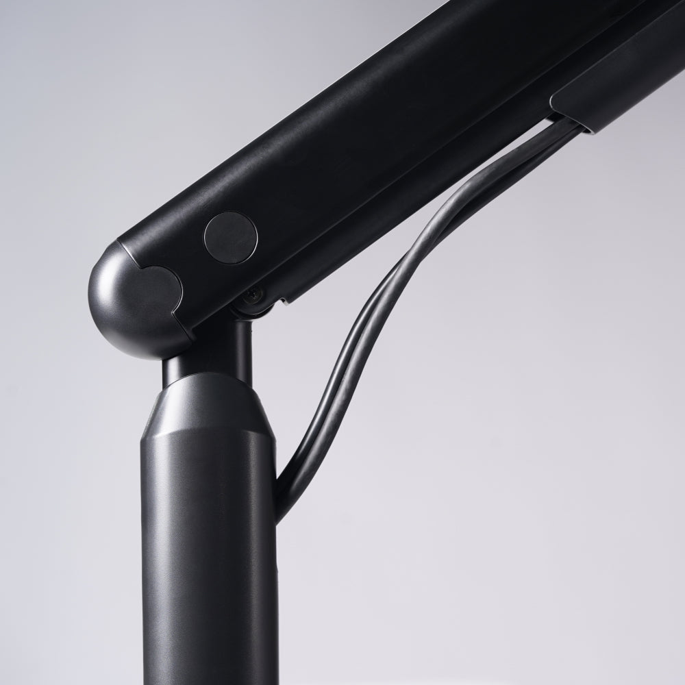 Close-up of a black adjustable Single Monitor Arm with visible cables, set against a light gray background—ideal for enhancing your ergonomic workspace or pairing seamlessly with your monitor setup.