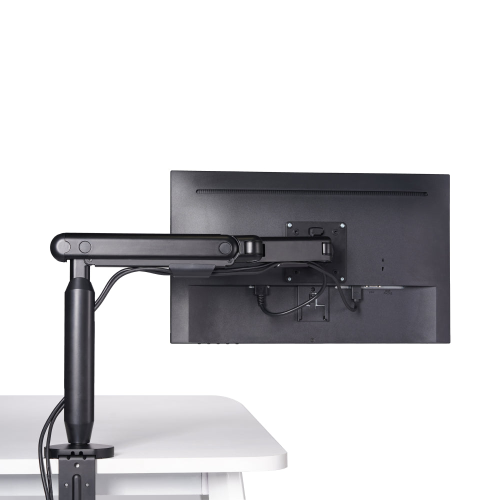 The Single Monitor Arm, in black, is mounted on a white desk and supports a flat-screen monitor. Its sleek design keeps cables organized for an ergonomic workspace, all set against a plain white background.