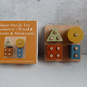 A Montessori Wood & Silicone Shape Puzzle consisting of a square wooden shape sorter with four geometric pieces and its corresponding orange cardboard box.
