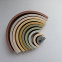 Silicone Rainbow Stacking Toy (10 pc) featuring ten nested silicone arches in graduated muted earth tones.