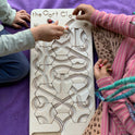 Two children playing with The Oort Cloud – Wooden Marble Run Puzzle on a purple blanket.