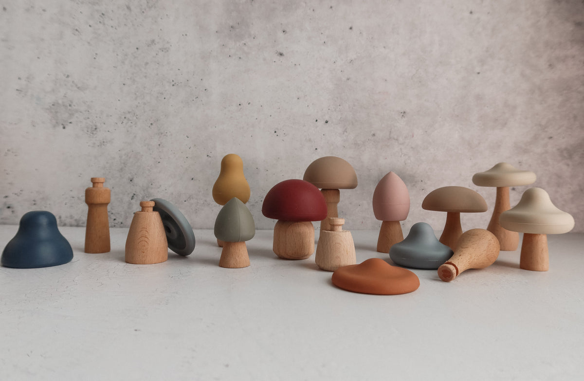 Mushroom Mix & Match Sorting Toy (24 pc) featuring a collection of wooden and silicone mushroom-shaped pieces in various colors and shapes, designed to help develop fine motor skills.