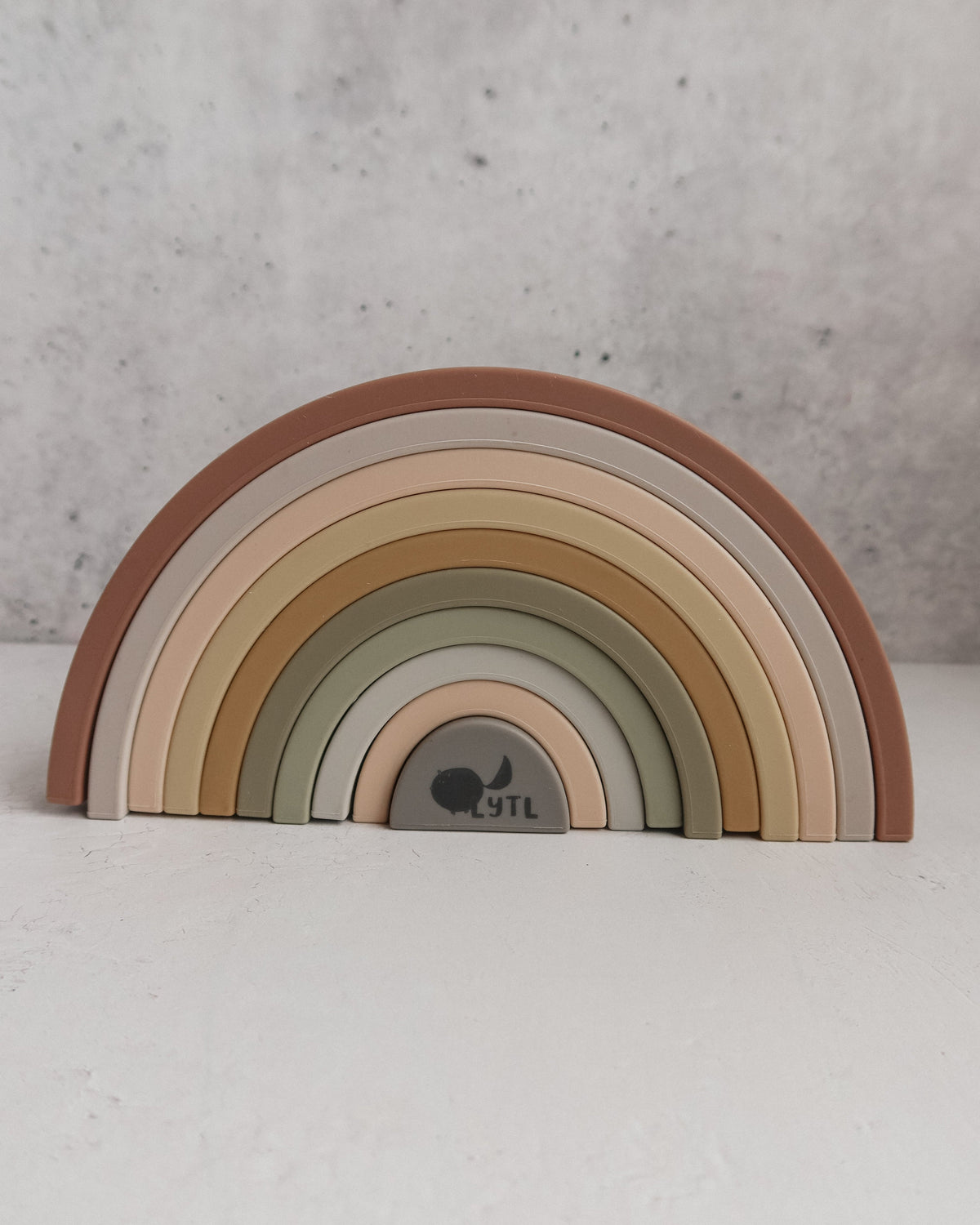 Silicone Rainbow Stacking Toy (10 pc) featuring ten arched pieces in muted earth tones.
