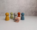 Six colorful Silicone Mini Peg Dolls (Set of 6) for pretend play, with one peach-colored doll lying on its side to reveal a logo on the bottom.