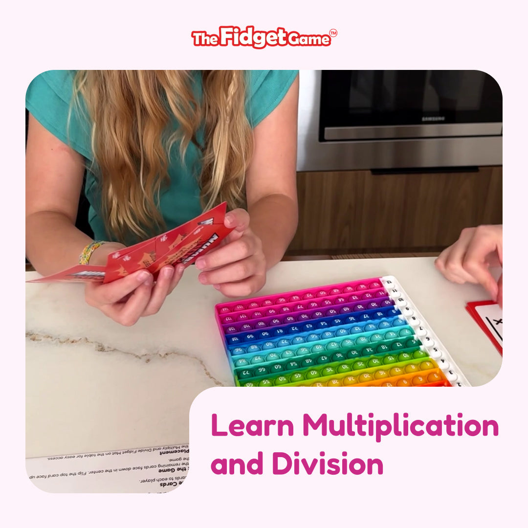A child holds cards while playing the Number Ninja Multiplication & Division Game on a colorful, square pop-it mat printed with a multiplication table for practicing math facts.