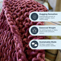 A close-up of the Velvet Weighted Blanket, a chunky woven mauve throw draped on a couch. Overlaid text features its cozy comfort, gentle hugging sensation, balanced weight, and eco-friendly fabric from recycled plastic bottles.