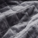 Close-up of a grey Gravity Original Weighted Blanket (10–25 lb) with a breathable cover and a quilted square pattern.