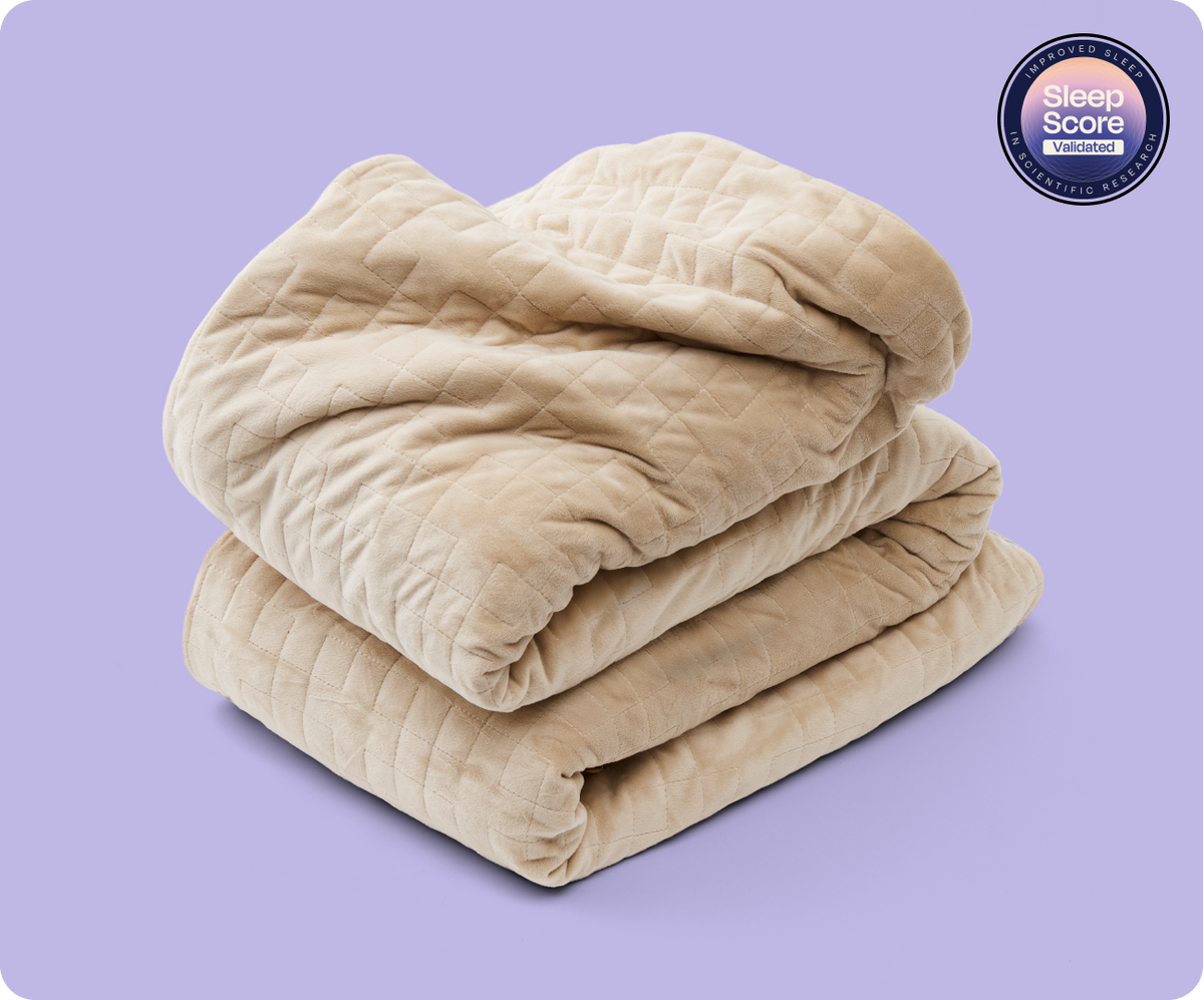 Folded oat-colored Gravity Original Weighted Blanket (10–25 lb) with a breathable cover, a quilted pattern, and a SleepScore validated badge in the corner.