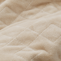 Close-up of a tan Gravity Original Weighted Blanket (10–25 lb) with a quilted square pattern and breathable cover.